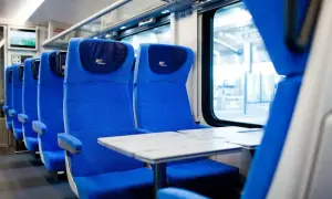 Wygodne siedzenia w pociągu PKP Intercity, gotowe na podróż z bagażem.