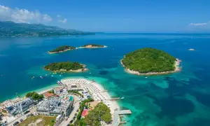Rajskie wyspy i turkusowe morze – idealne miejsce na albania wakacje. Widok z lotu ptaka na plażę z leżakami i hotele.