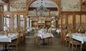 Elegancka restauracja w hotelu 5 gwiazdkowym, z drewnianymi zdobieniami i przytulnym kominkiem.