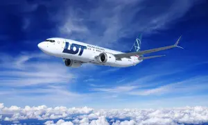 Samolot LOT Polish Airlines leci na tle błękitnego nieba z chmurami.