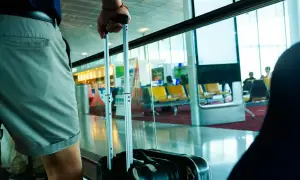 Osoba z walizką, gotowa do podróży z flydubai. Bagaż podręczny czeka na lotnisku.