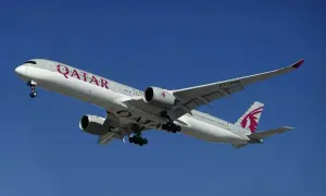 Samolot Qatar Airways z wysuniętym podwoziem, gotowy do lądowania. Pamiętaj o limitach bagażu podręcznego!