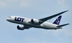 Samolot LOT Polish Airlines z numerem lotu SP-LRF wznosi się na błękitne niebo.