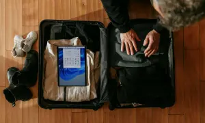 Pakowanie walizki: ubrania, buty i tablet. Zastanawiasz się, czy w bagażu rejestrowanym można mieć płyny? Sprawdź zasady przed podróżą.