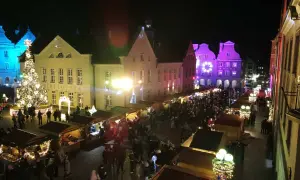 Tłoczny jarmark bożonarodzeniowy Olsztyn nocą. Rozświetlona choinka, stragany i kolorowe iluminacje budzą świąteczny nastrój.