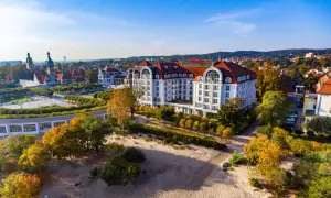 Hotel Sheraton Sopot z widokiem na plażę i jesienne drzewa.
