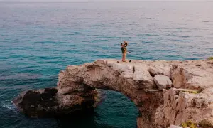 Para idealne na wakacje w listopadzie gdzie najcieplej. Para na skale nad turkusowym morzem.