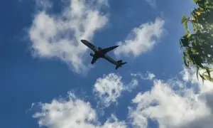 Samolot PLL LOT leci na tle błękitnego nieba z chmurami. Zastanawiasz się, ile trwa lot do Turcji Antalya?