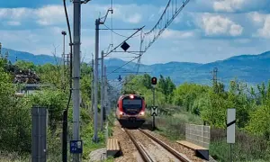 Pociąg zbliża się do stacji, a krajobraz zapowiada podróż, jak dojechać pociągiem do Krynicy-Zdroju.