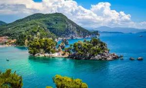 Malownicze **Lefkada loty z Polski** to marzenie o rajskich wakacjach. Widok na turkusowe morze, zielone wzgórza i urokliwą zatoczkę z białą kapliczką.