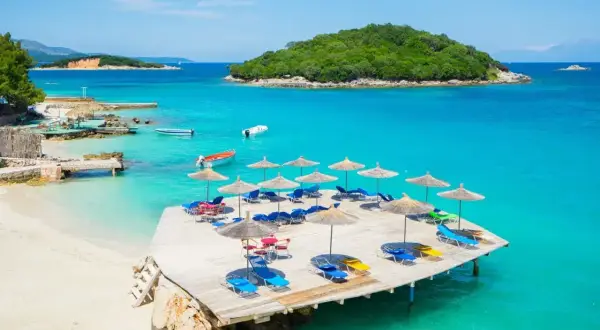 Rajskie albania plaże z turkusową wodą, leżakami i parasolami. Idealne miejsce na relaks.