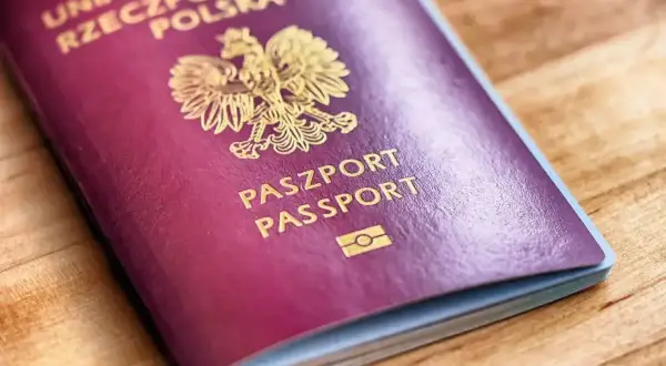 Polski paszport na drewnianym tle. Czy do Grecji potrzebny jest paszport? Tak, jeśli nie jesteś obywatelem UE.