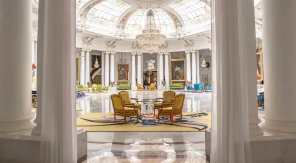 Eleganckie wnętrze hotelu Best Negresco z kryształowymi żyrandolami, marmurową posadzką i luksusowymi meblami.