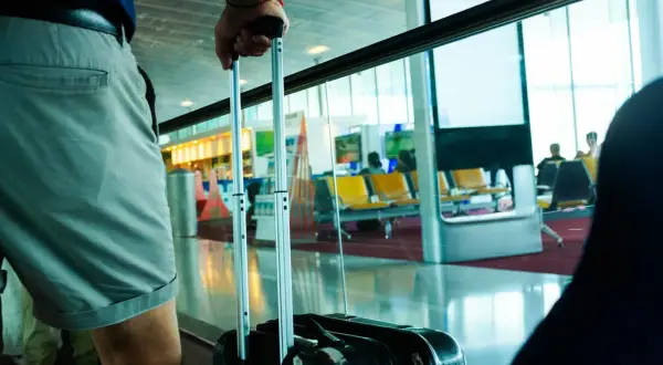 Osoba z walizką, gotowa do podróży z flydubai. Bagaż podręczny czeka na lotnisku.