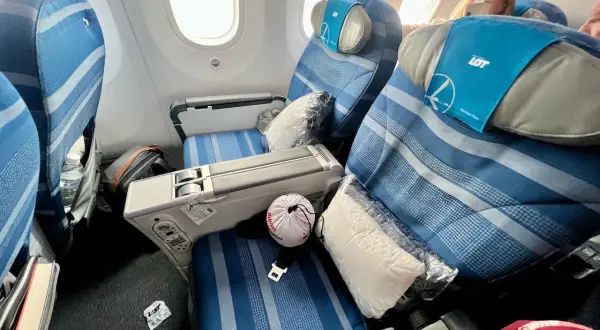 Komfortowe fotele w klasie premium economy LOT. Poduszka i koc czekają na pasażera.