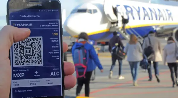 Telefon z kartą pokładową Ryanair w ręku, gotowy do podróży. Jak wydrukować bilet Ryanair? Wystarczy mieć go w aplikacji!