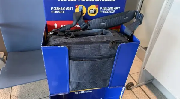 Czy Ryanair mierzy plecaki? Widać to na zdjęciu, gdzie torba próbuje zmieścić się w wyznaczonym miejscu.