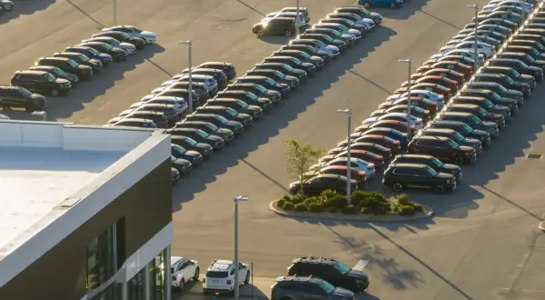 Duży parking lotniskowy w Düsseldorfie, pełen rzędów nowych samochodów. Zastanawiasz się, ile kosztuje parking na lotnisku w Düsseldorfie?