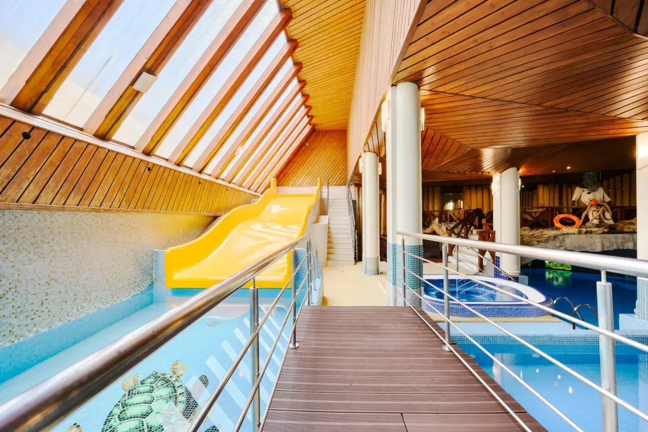 Wodne szaleństwo w hotelu Belvedere Resort & Spa! Żółta zjeżdżalnia wodna i basen z mozaiką żółwi czekają na gości.