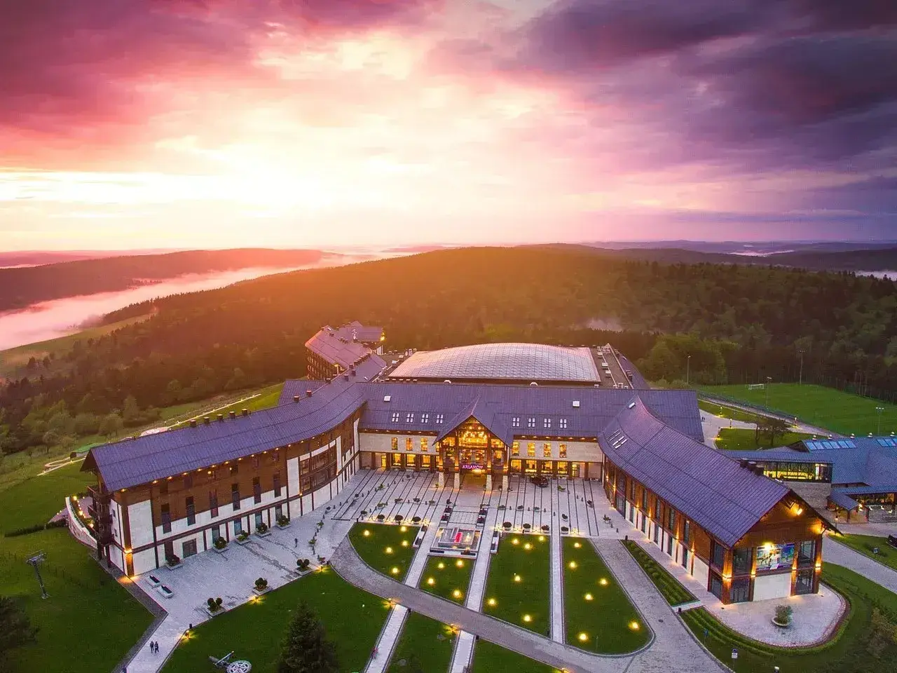 Hotel Arłamów w malowniczej scenerii o zachodzie słońca. Sprawdź hotel Arłamów ceny i zarezerwuj pobyt.