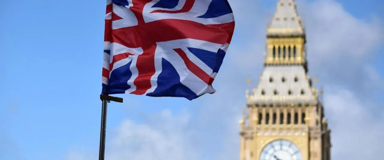 Flaga Wielkiej Brytanii powiewa przed Big Benem. Marzenie o podróży i uzyskaniu wizy do Londynu staje się realne.