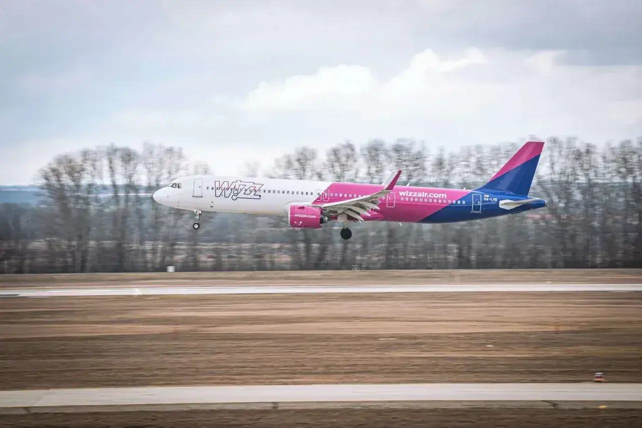 Samolot Wizz Air ląduje na pasie startowym. Wizz rozkład miejsc w samolocie Wizzair jest dobrze widoczny.
