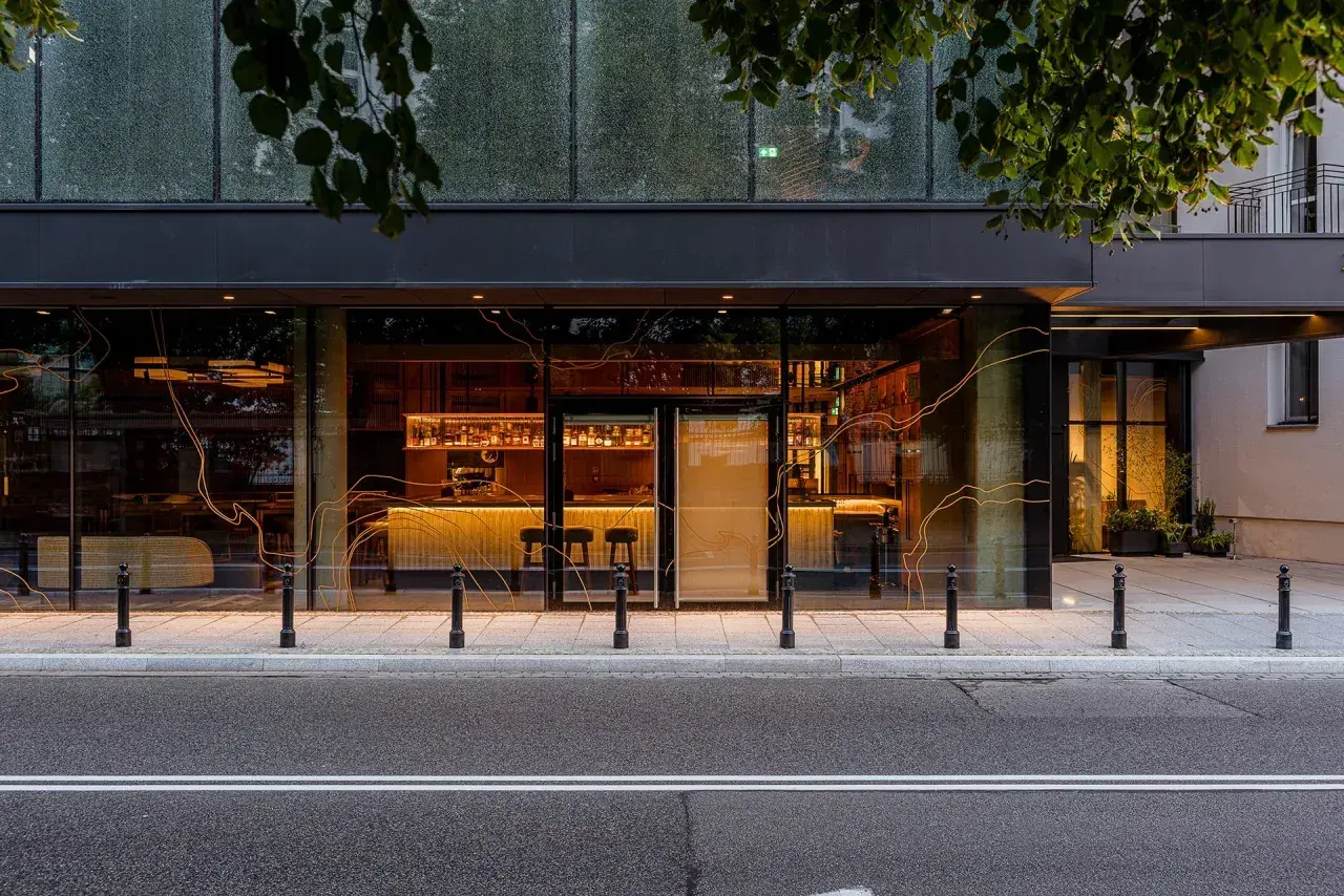 Elegancki bar i restauracja w hotelu Nobu Warszawa, widoczne przez duże okna.