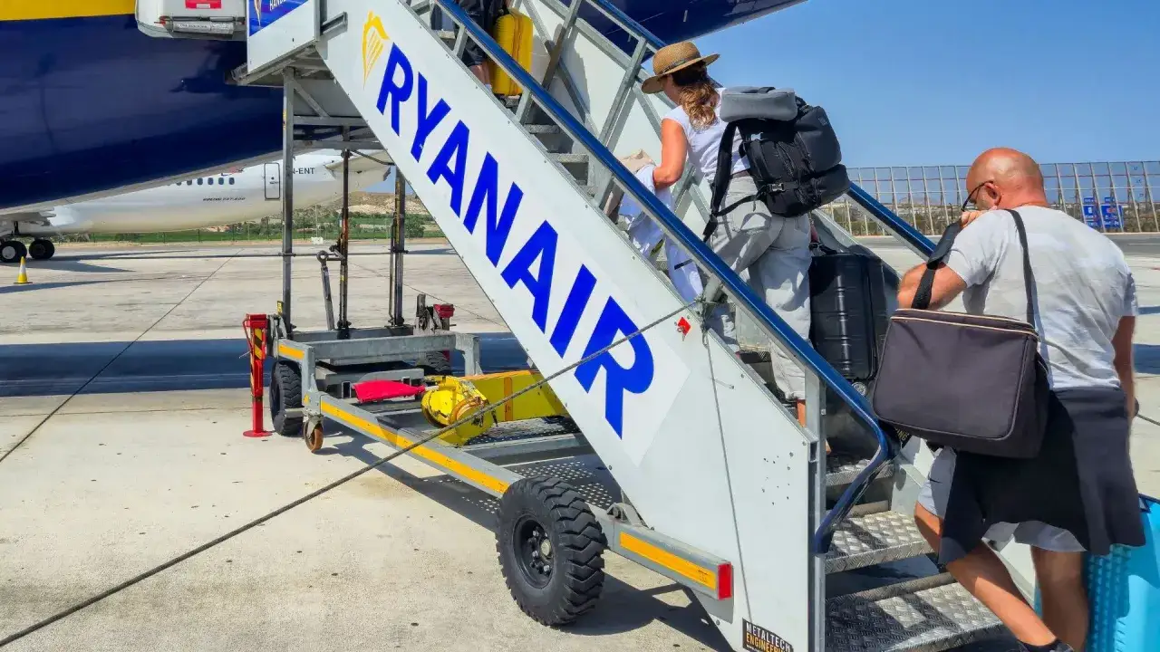 Ludzie wchodzą po schodkach z napisem RYANAIR. Może to początek podróży z 10% zniżki?