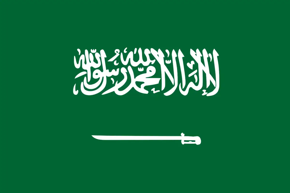 Flaga Arabii Saudyjskiej z napisem po arabsku i szablą. Planujesz podróż? Sprawdź wymagania dotyczące wizy do Arabii Saudyjskiej.