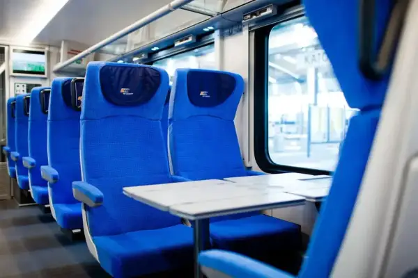 Wygodne siedzenia w pociągu PKP Intercity, gotowe na podróż z bagażem.