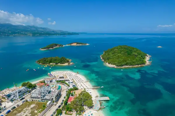 Rajskie wyspy i turkusowe morze – idealne miejsce na albania wakacje. Widok z lotu ptaka na plażę z leżakami i hotele.