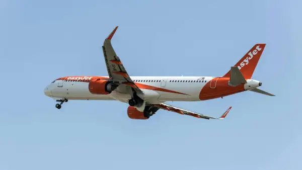Samolot easyJet w locie, z widocznymi silnikami i skrzydłami. Idealny do podróży z bagażem podręcznym.