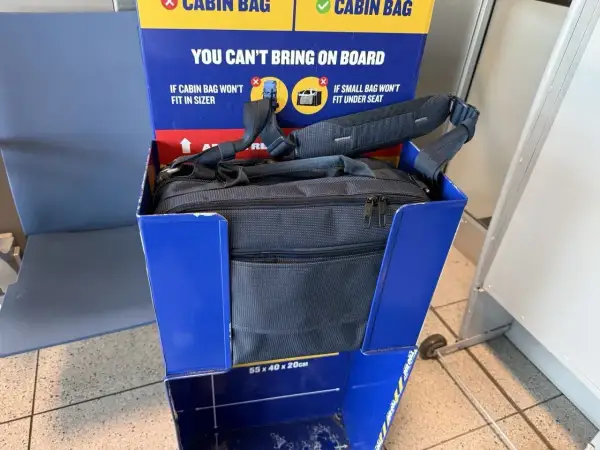 Torba podróżna w niebieskim stojaku Ryanair. Sprawdź, co można przewozić w bagażu rejestrowanym Ryanair, aby uniknąć problemów.