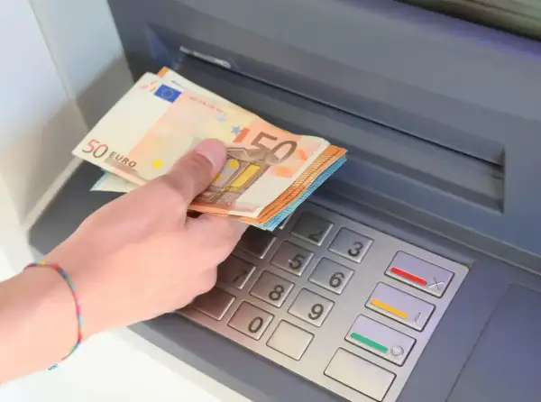 Ręka z banknotami 50 euro przy bankomacie. W Hiszpanii, jak w całej strefie euro, obowiązuje euro.
