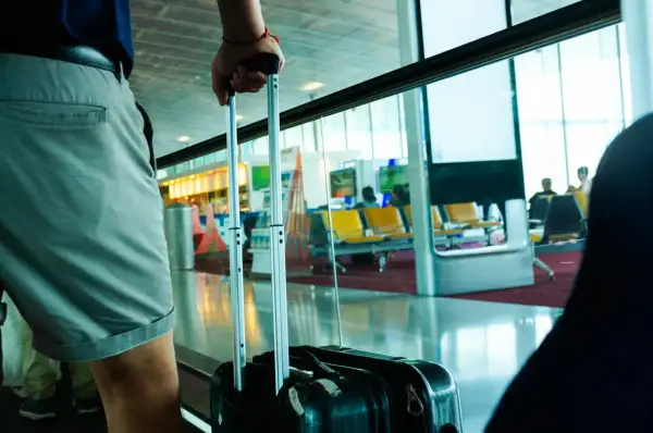 Osoba z walizką, gotowa do podróży z flydubai. Bagaż podręczny czeka na lotnisku.