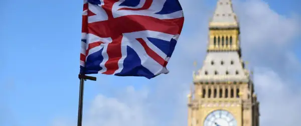 Flaga Wielkiej Brytanii powiewa przed Big Benem. Marzenie o podróży i uzyskaniu wizy do Londynu staje się realne.