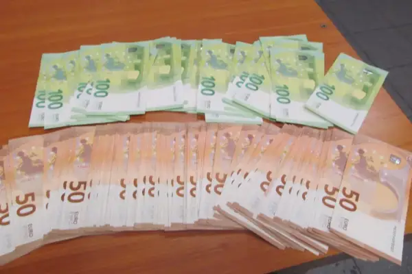 Stosy banknotów 100 i 50 euro na drewnianym stole. Taki widok może towarzyszyć przewozowi gotówki w strefie Schengen.