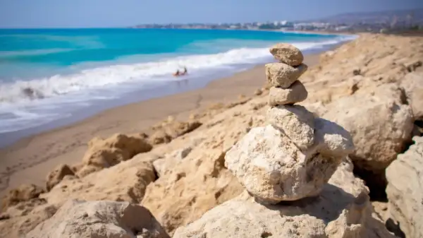 Kamienna wieża na skalistym brzegu, w tle turkusowe morze i piaszczyste plaże Pafos.