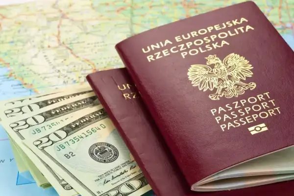 Paszporty i dolary na tle mapy. Planujesz podróż? Sprawdź, czy do Rumunii potrzebny jest paszport.